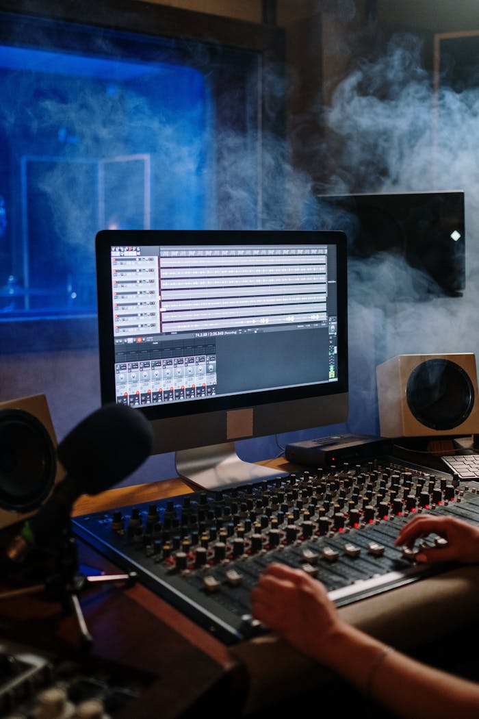 gallery-2 A modern music studio with audio mixer and computer screen displaying tracks.