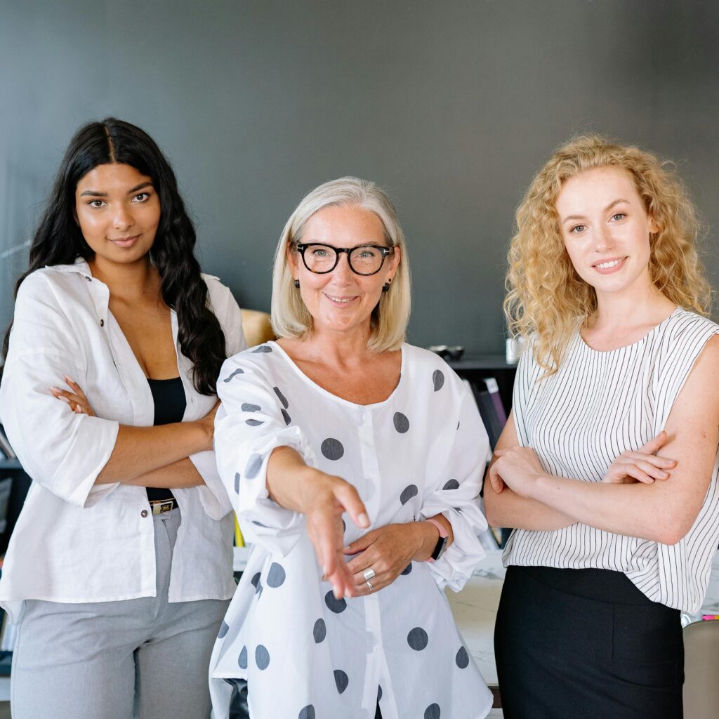 pexels photo 8837170 8837170 Three diverse businesswomen standing confidently in an office, showcasing teamwork and professionalism.